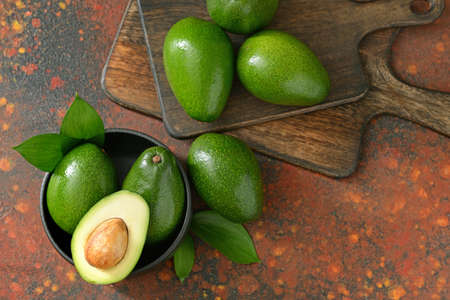 Fresh ripe avocados with boards on color background