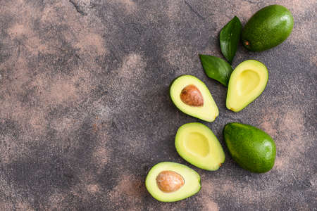 Fresh ripe avocados on gray background