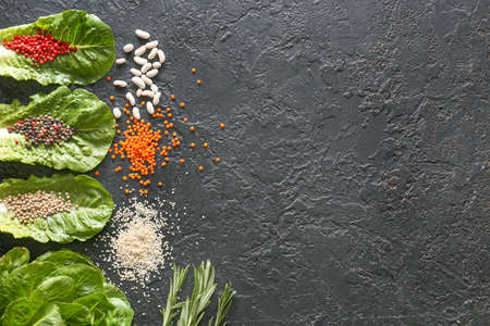 Different herbs, legumes and spices on dark background