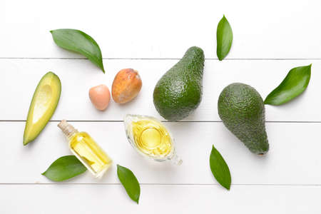 Fresh ripe avocados with essential oil on white wooden backgroundの写真素材