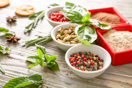 Different herbs and spices on wooden background
