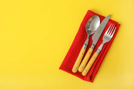 Cutlery and napkin on color backgroundの写真素材