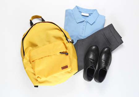 Stylish school uniform with backpack on white background