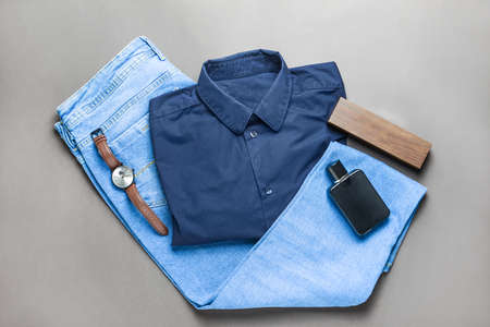Stylish male look with jeans clothes on gray background