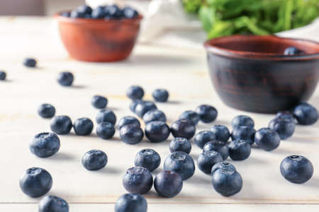 Many ripe blueberry on white table