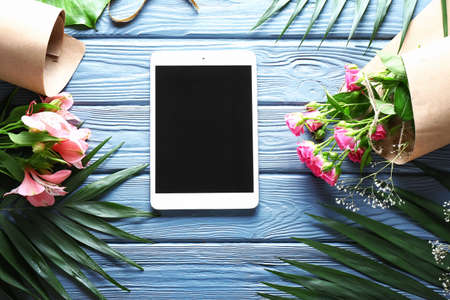 Modern tablet computer on workplace of florist