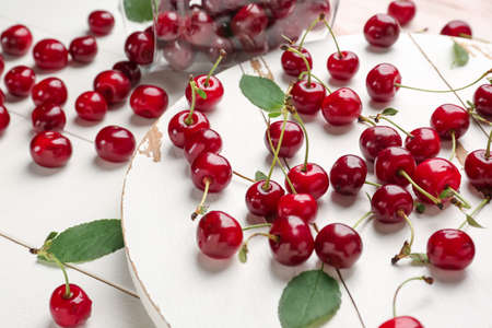 Scattered ripe cherry on white wooden background