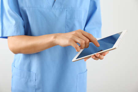 Nurse with tablet computer on light background, closeupの写真素材