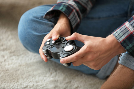 Teenager playing video game at home, closeup