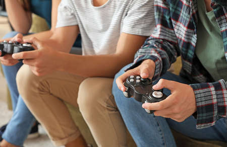 Teenagers playing video game at home