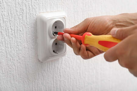 Electrician repairing socket in room, closeup
