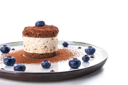 Plate with tasty cake and blueberry on white background
