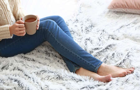 Young woman drinking hot tea at home