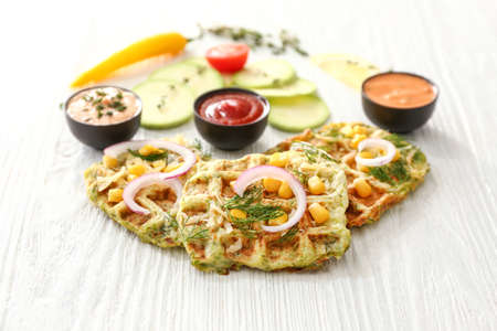 Tasty squash waffles with sauces on white tableの写真素材