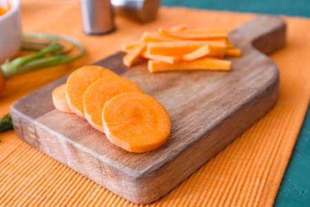 Pieces of fresh carrots on wooden board