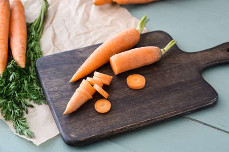 Cutting board with fresh carrots on table