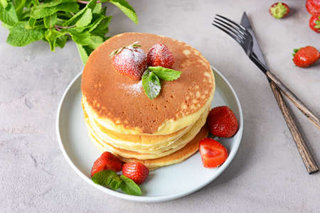 Plate with tasty pancakes and strawberry on table