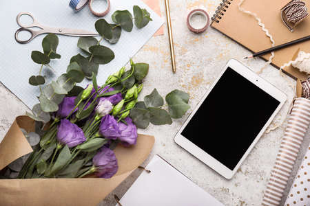Modern tablet computer and accessories on workplace of floristの写真素材