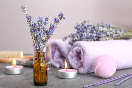 Bottle with lavender flowers on gray tableの写真素材