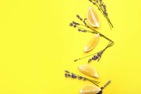 Beautiful lavender flowers with lemon pieces on color background