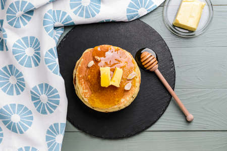 Tasty pancakes with butter and honey on tableの写真素材