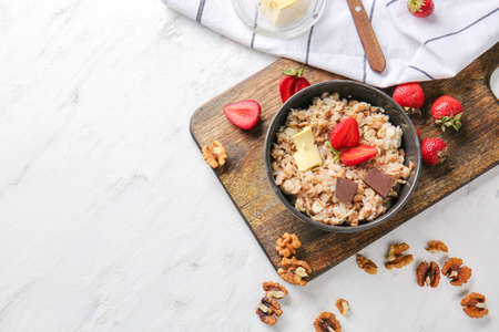 Bowl with tasty sweet oatmeal on light tableの写真素材