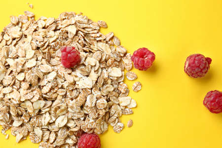 Oat flakes with raspberry on color background