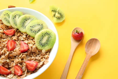 Bowl with tasty sweet oatmeal on color background