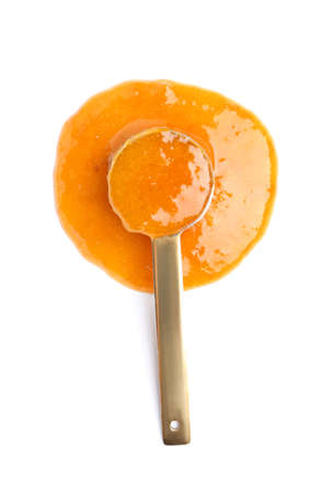 Scoop with tasty apricot jam on white backgroundの写真素材