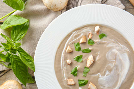 Plate of tasty mushroom cream soup on tableの写真素材