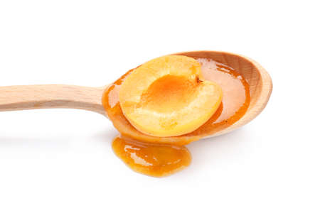 Spoon with tasty apricot jam on white background, closeupの写真素材