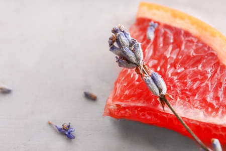 Lavender flowers with grapefruit slice on gray backgroundの写真素材