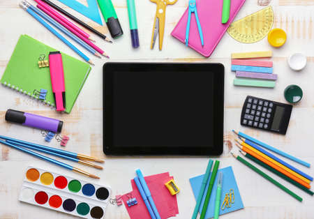 Set of school supplies with tablet computer on white wooden backgroundの写真素材