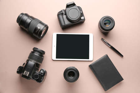 Tablet computer and set of photographer's equipment on color backgroundの写真素材