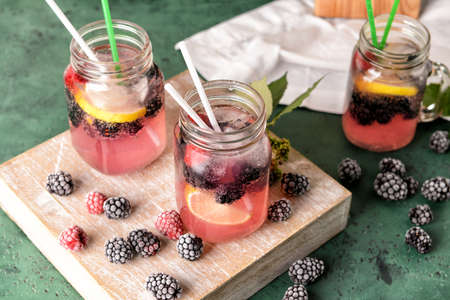 Mason jars of tasty blackberry lemonade on tableの写真素材
