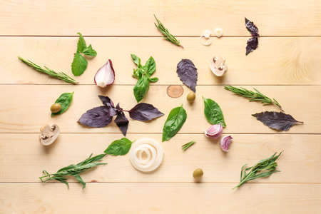Fresh herbs with vegetables on wooden background