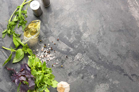 Different fresh herbs with oil, spices and garlic on grunge backgroundの写真素材