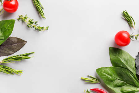 Fresh herbs with tomatoes on white background