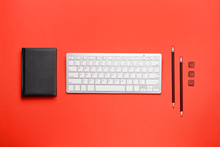 Modern computer keyboard with stationery on color backgroundの写真素材