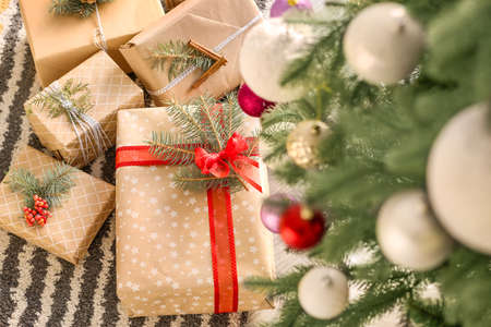 Beautiful gift boxes under fir tree in roomの写真素材