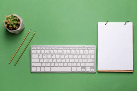 Modern computer keyboard with stationery on color backgroundの写真素材