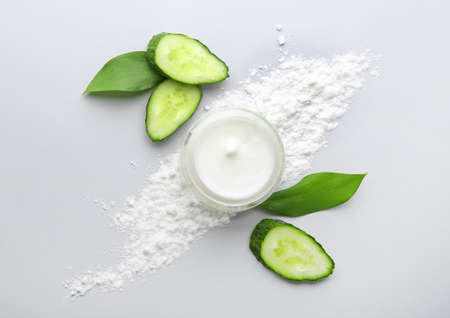 Jar of body cream and cucumber slices on white backgroundの写真素材