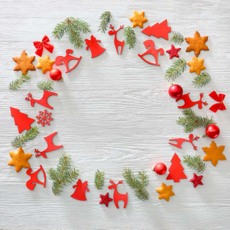 Frame made of Christmas decor and cookies on light wooden background