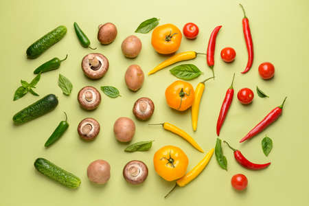 Assortment of fresh vegetables and mushrooms on color background