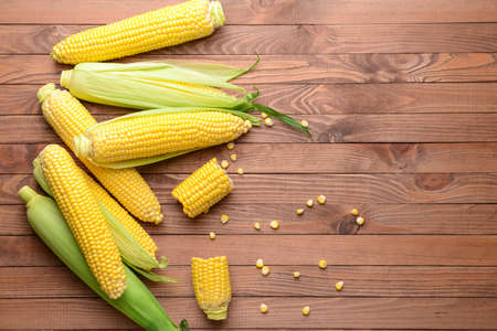 Fresh corn cobs on wooden backgroundの写真素材