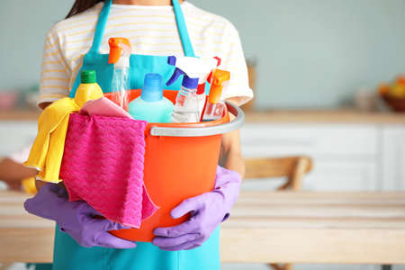 Woman with cleaning supplies in kitchen