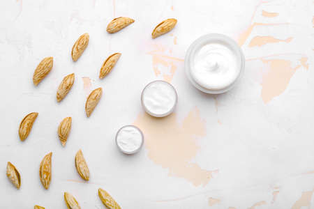 Jars of natural cream and almonds on light backgroundの写真素材