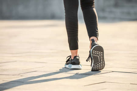 Legs of sporty young woman running outdoors