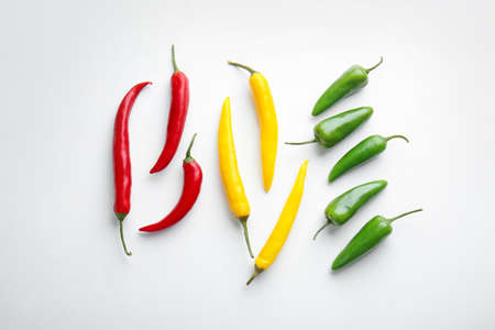 Different fresh chili peppers on white background