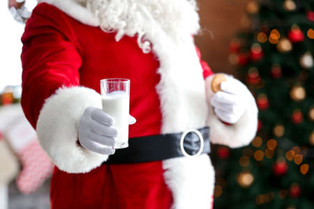 Santa Claus with milk and cookie in room decorated for Christmas, closeupの写真素材